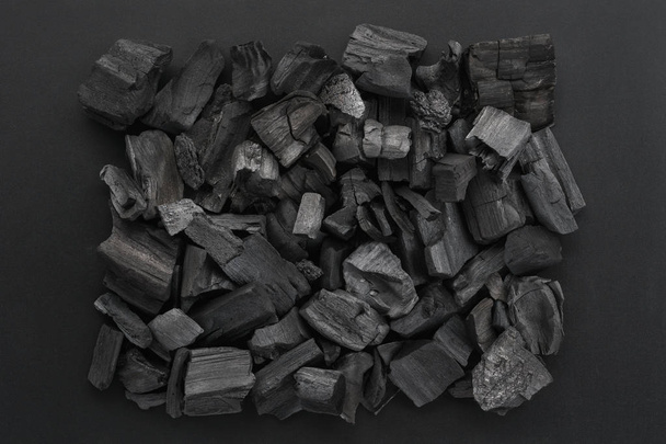 Charcoal pieces on black frame background, flat lay. - Fotoğraf, Görsel