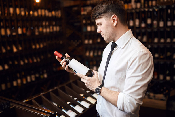 handsome elegant man helping customers to choose wine - Zdjęcie, obraz
