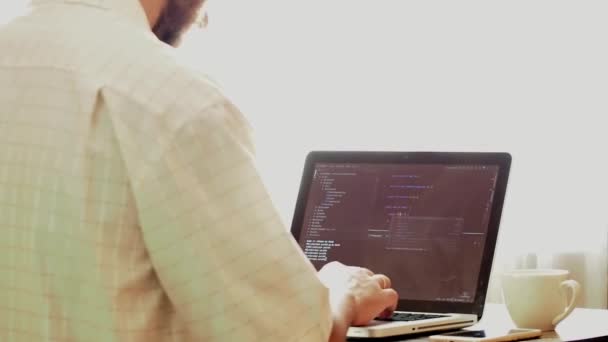 Programador joven que codifica en un ordenador portátil en el lugar de trabajo de la oficina
 - Imágenes, Vídeo