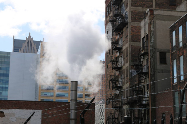 Urban cityscape of fire escapes, barbed wire and pollution.  A grimy city scene.    - Фото, изображение
