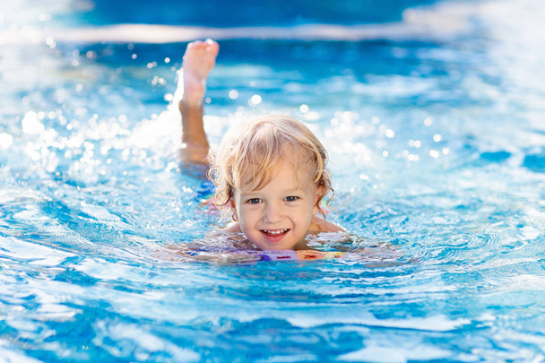 Child learning to swim. Kids in swimming pool. - Fotoğraf, Görsel