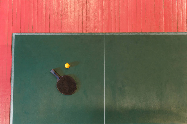 Racquet and tennis ball on a green table tennis - Фото, зображення