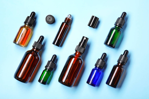 Flat lay composition with cosmetic bottles of essential oils on color background - Photo, Image