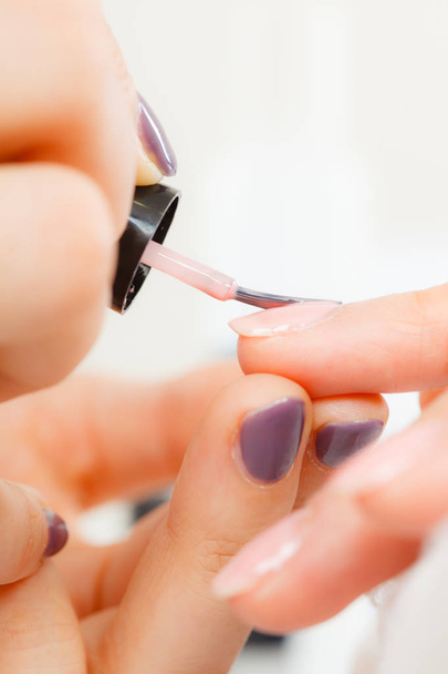 Woman in beauty salon getting manicure done. - Фото, изображение