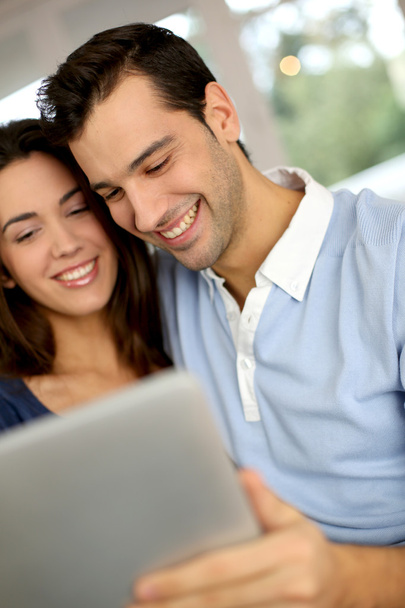 Smiling couple websurfing on internet with tablet - Fotografie, Obrázek