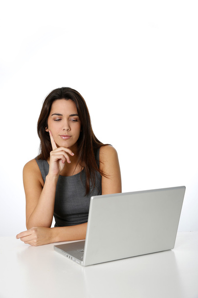 Young woman with thoughtful look in front of laptop - Photo, Image
