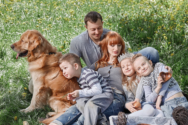 happy family with three kids sitting on the grass in a Sunny Park - Zdjęcie, obraz