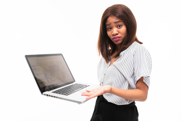 smilling dark-skinned young girl present smth on the laptop isolated on background - Photo, Image