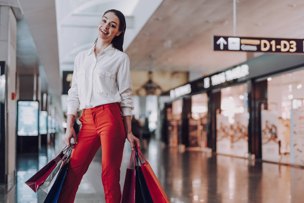Happy young woman at airport after shopping - Foto, Imagem