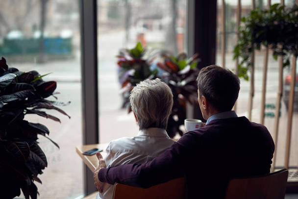 Back side beloved aged couple sitting in cafe - Foto, afbeelding