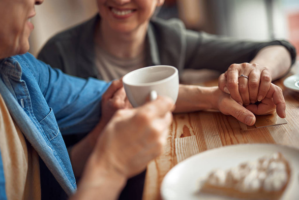 Close up mature happy couple holding hands in cafe - Foto, Imagen