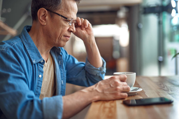 Casual style aged man sitting in cafe with coffee - Photo, image