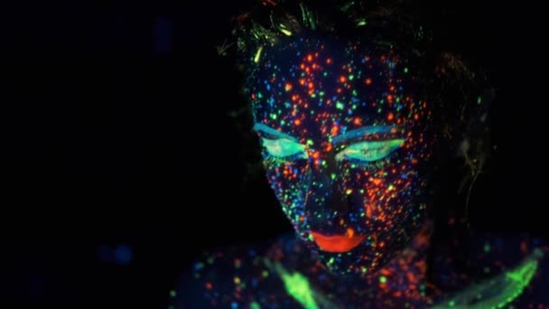 filles visage dans la lumière du néon. portrait d'une jeune femme colorée avec des peintures lumineuses
. - Séquence, vidéo