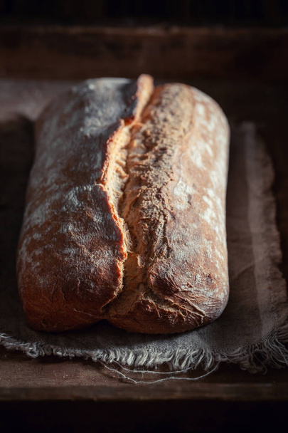 Healthy and big loaf of bread on rustic table - Фото, изображение