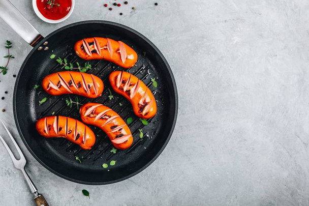 Grilled sausages in cast iron pan.  - Fotó, kép
