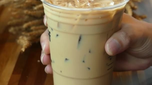 Plastic glass handle with coffee and ice inside to shake - Кадри, відео