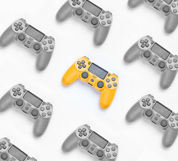 Black and white photo with  selective yellow color, many gamepads. Game workspace. The concept individuality. Creative background. Top view - Photo, Image