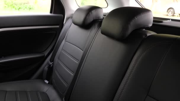 artificial leather rear seats in the car. beautiful leather car interior design. luxury leather seats in the car. Black leather seat covers in the car. - Footage, Video