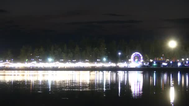 Éjszakai hinták a folyó mentén éjszakai piaccal, - Felvétel, videó