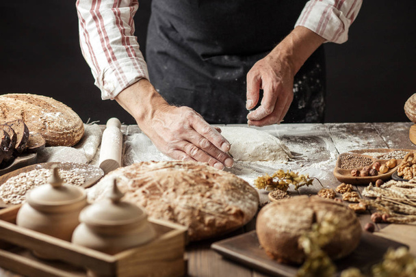 Close up of baker hands kneading dough and making bread with a rolling pin. - Valokuva, kuva