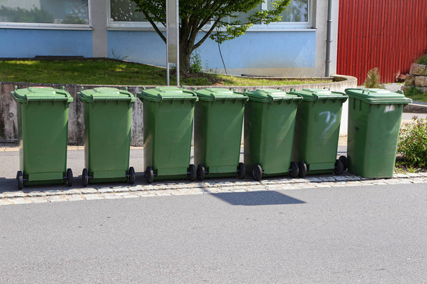 На вулиці зелені сміттєві баки
 - Фото, зображення