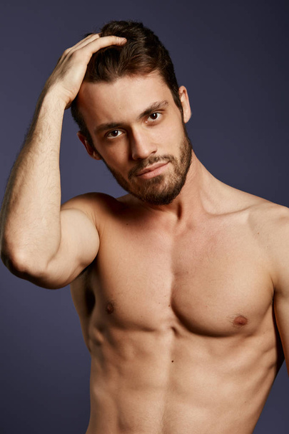 attractive awesome male model with hand on his head looking at the camera - Photo, Image