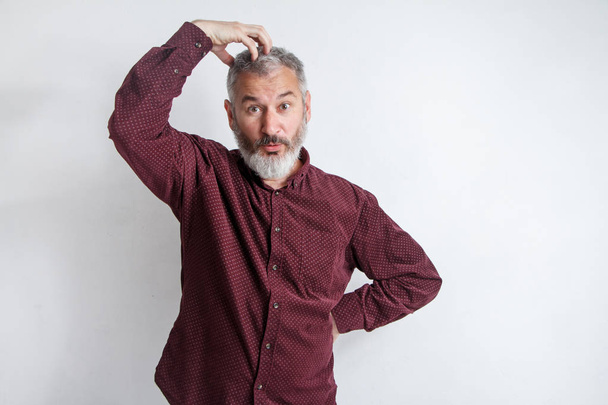 Portrait gray bearded man has an idea, hand at the head up isolated on white wall background - 写真・画像
