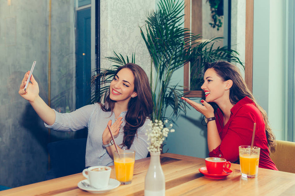 zwei Freundinnen haben Spaß im Café und machen Selfie mit sma - Foto, Bild