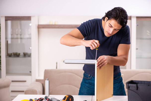 jeune homme réparer des meubles à la maison  - Photo, image