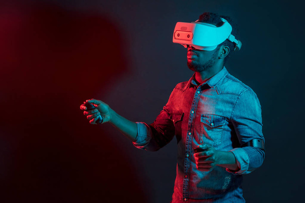African Man in white, wearing VR Headset on red and blue dual color background. - Valokuva, kuva