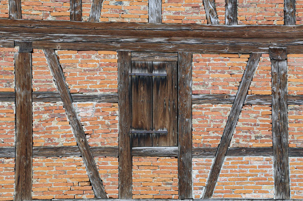Parede de tijolos vermelhos e vigas de madeira
 - Foto, Imagem