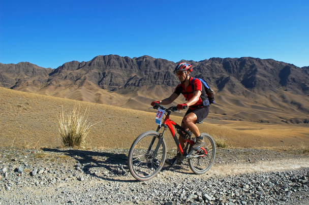 Motociclista de montaña en el viejo camino en el desierto
 - Foto, Imagen