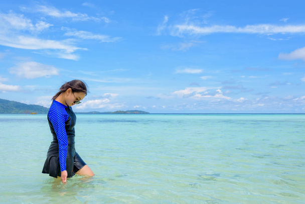 Азиатка, гуляющая по морю во время путешествия на остров Ко Липе (Koh Lipe)
 - Фото, изображение