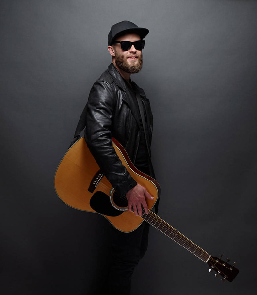 Guitar player with beard and black clothes - Foto, Imagen