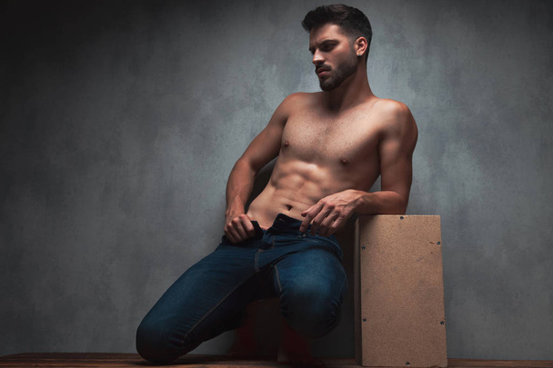 Charmante topless man poseren en trekken zijn jeans - Foto, afbeelding