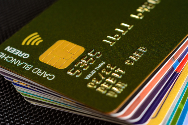 Close-up creditcard waar de chip duidelijk zichtbaar is op een zwarte achtergrond. - Foto, afbeelding