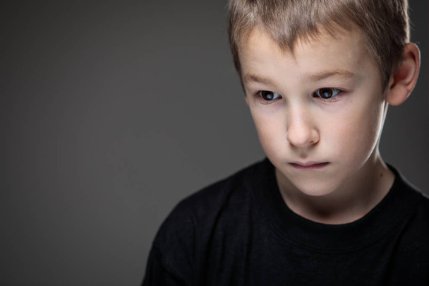 Grief-stricken little boy - feeling intense sorrow, remorse - Фото, изображение