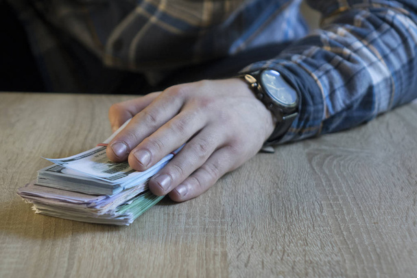 Мужчина считает деньги в руке. Финансы, сбережения, зарплата и пожертвования
. - Фото, изображение
