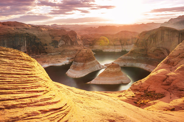 Niezwykłe naturalne tło. Reflection Canyon on on Lake Powell, Utah, USA. Inspirujące wędrówki scena-man spoczywa na pięknym punkcie zachodu słońca. - Zdjęcie, obraz