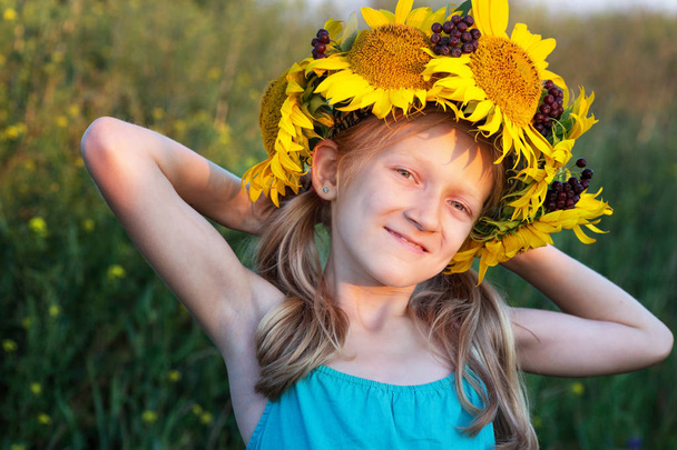Ukrainian kid girl at the field of sunflowers - Photo, Image