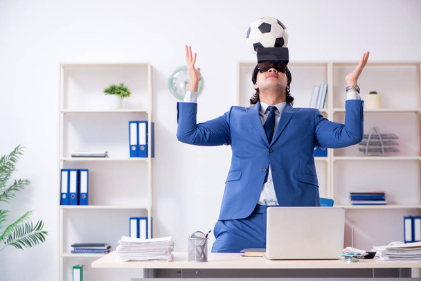 Young handsome businessman playing soccer with virtual glasses  - Foto, Imagem