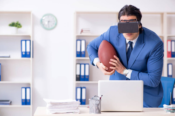 Giovane uomo d'affari bello giocare a rugby con occhiali virtuali
 - Foto, immagini