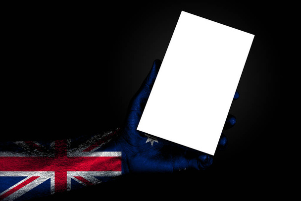 χέρι με ζωγραφισμένο σημαία Αυστραλία κρατώντας ένα μεγάλο λευκό φύλλο με χώρο για μια επιγραφή, μακέτα - Φωτογραφία, εικόνα