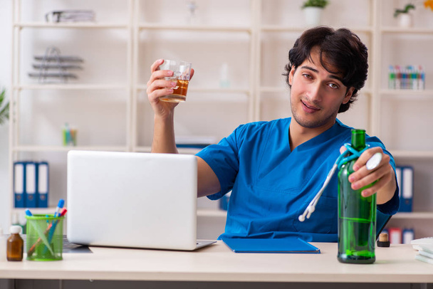 Jeune médecin homme buvant au bureau  - Photo, image