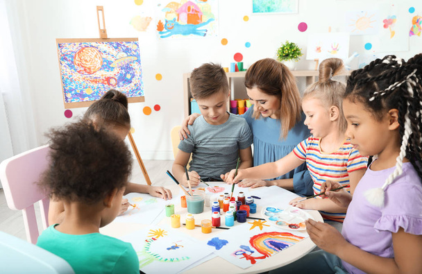 Children with female teacher at painting lesson indoors - Foto, Bild