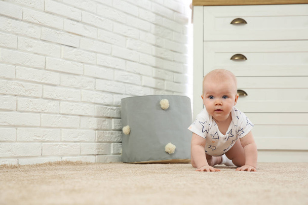 Cute little baby crawling on carpet indoors - Фото, изображение