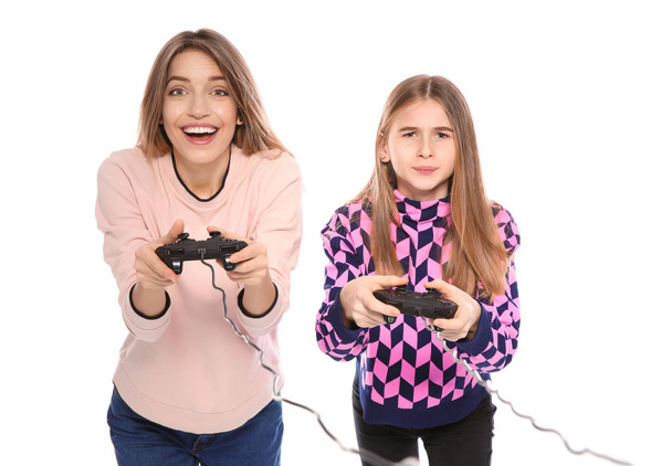 Young woman and teenage girl playing video games with controllers isolated on white - Photo, Image