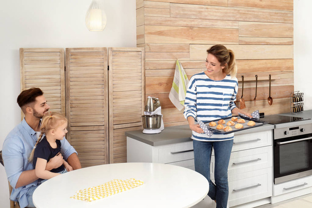 Young woman treating her family with homemade oven baked cookies in kitchen - Φωτογραφία, εικόνα
