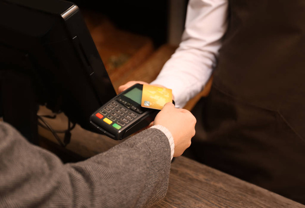 Женщина с кредитной картой с помощью платежного терминала в магазине, крупным планом
 - Фото, изображение