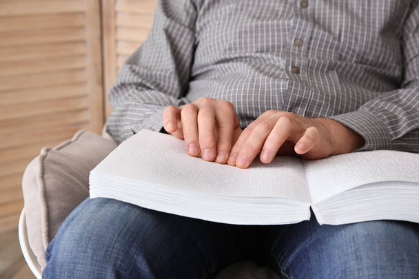 Blind man reading book written in Braille at home, closeup - Фото, зображення